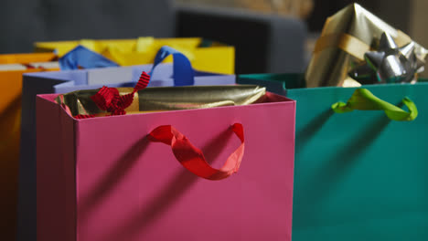 Close-Up-Of-Gift-Wrapped-Presents-In-Colourful-Bags-With-Tag-On-Table-In-Lounge-At-Home-3